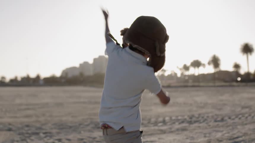 A young kid dances on the beach
