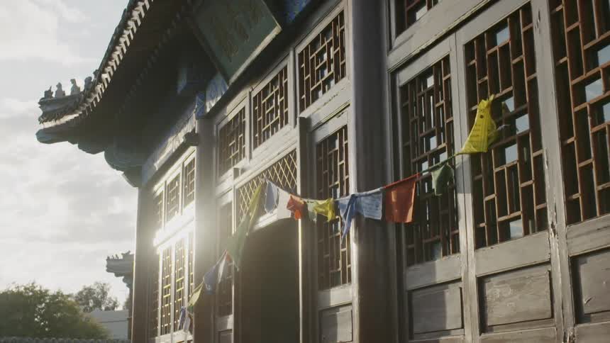 Sun shines and reflects off a building with flags hanging on it