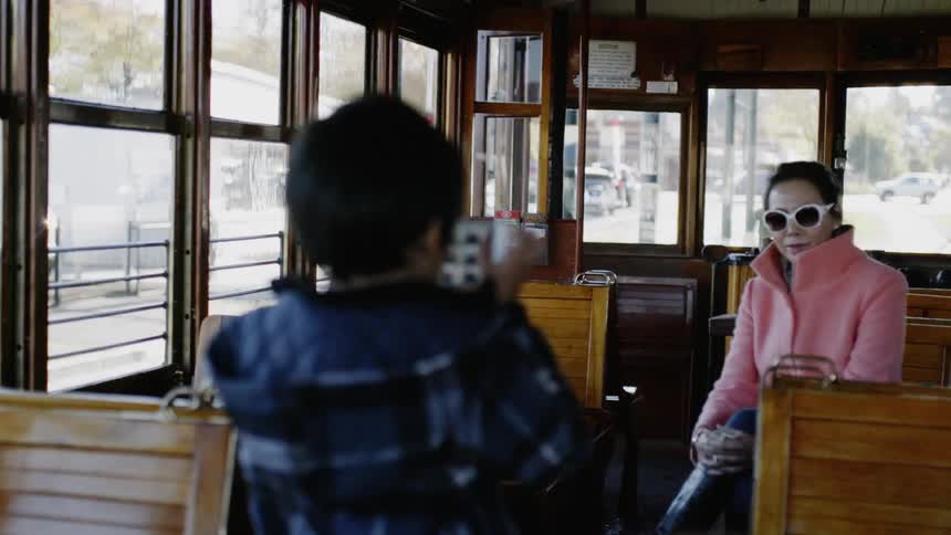 A child is photographing a woman with a phone