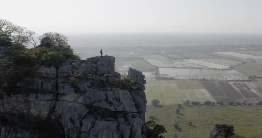Hiker stands on a mountain peak