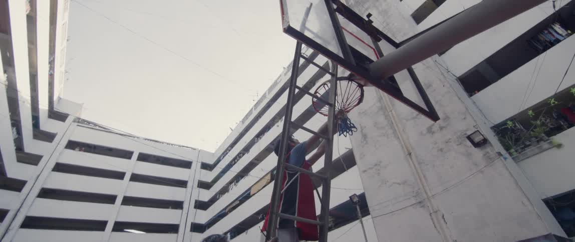 A boy untangles a basketball net