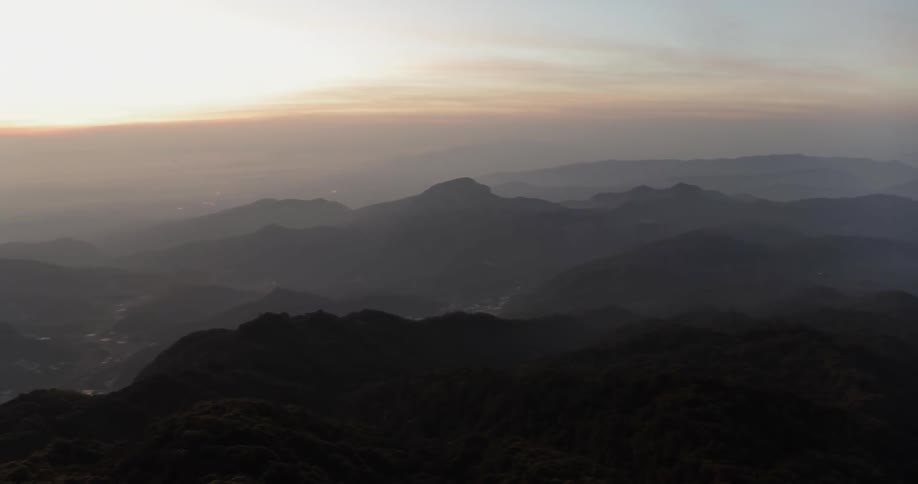 Mountains sit as the mist floats around its peaks