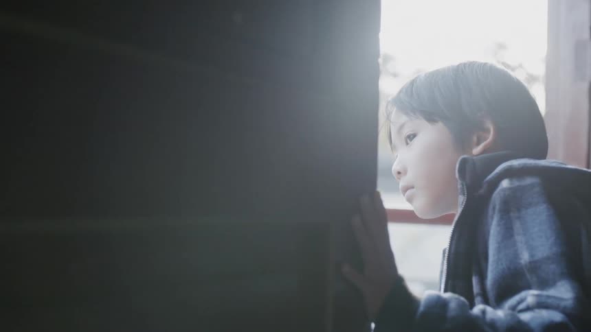 A child peeks around the corner