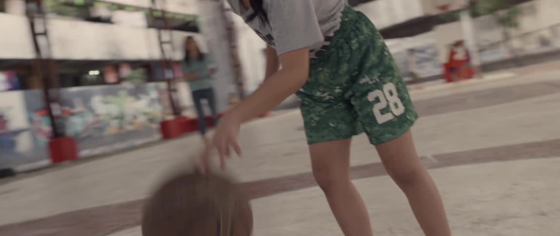 A girl is dribbling the basketball on the court