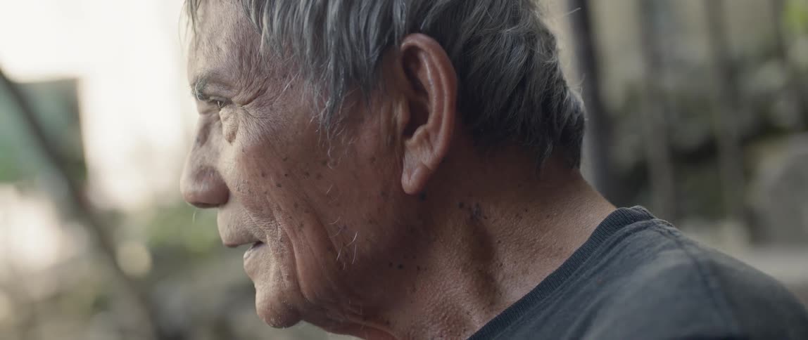 A man leans forward blinking