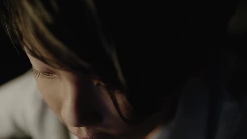 A boy looks down in concentration