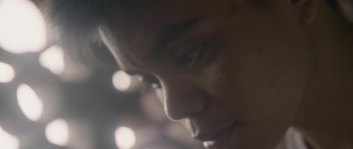 A man leans down looking at something by the bars