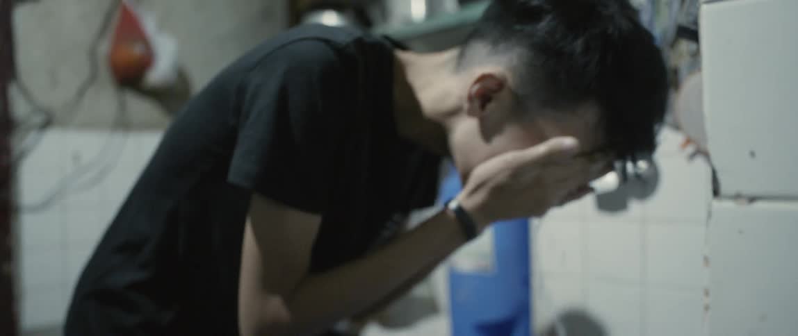 A child washes their face in the sink