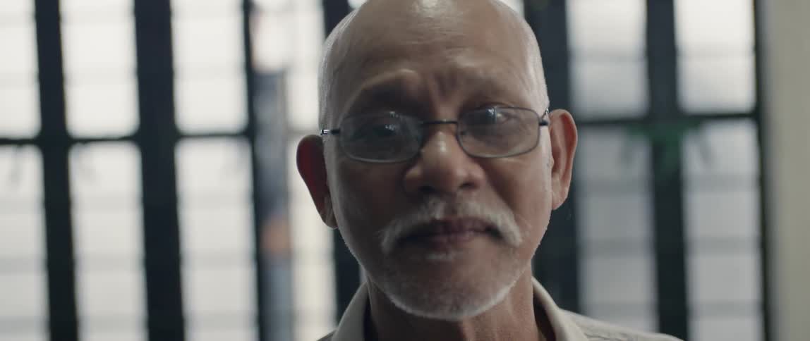 A man with glasses on stare straight ahead