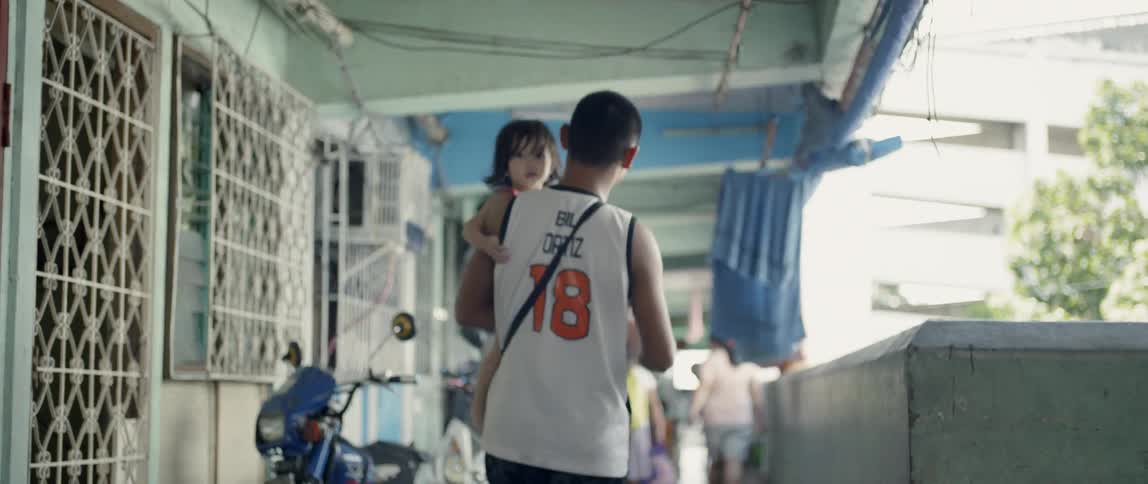 A man carries a child down the hallway