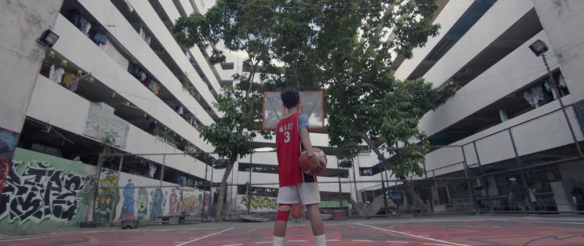 A child holds a basketball on the court