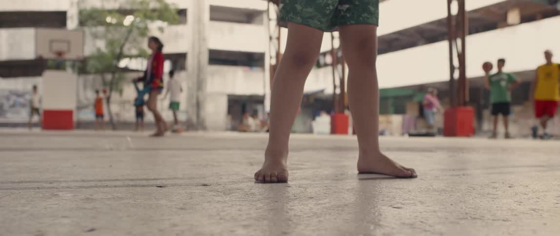 A child dribbles a basketball on concrete