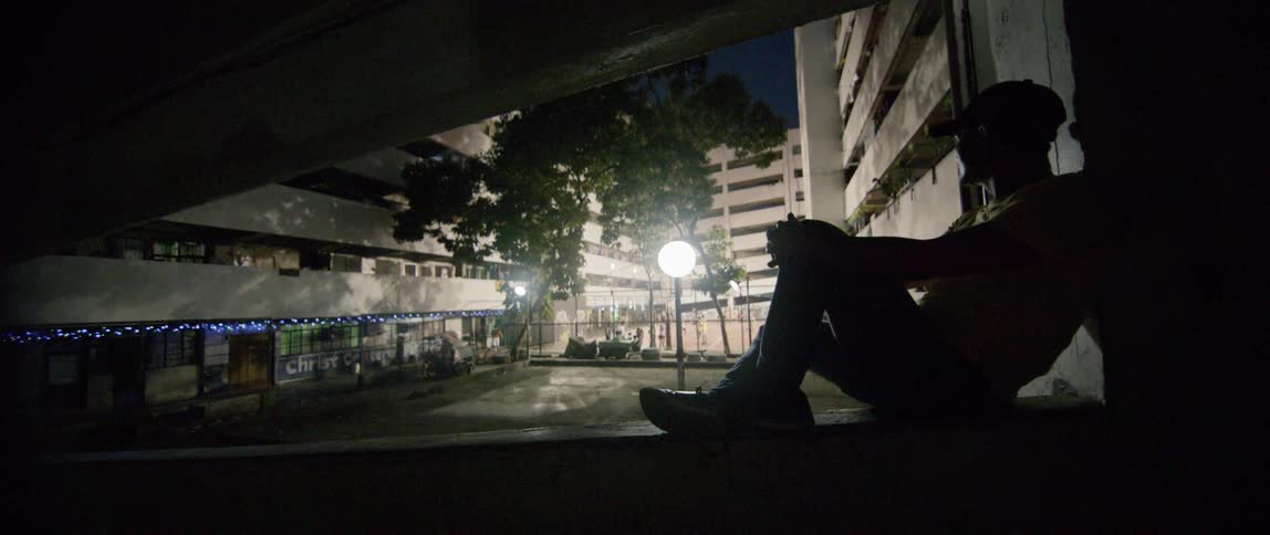 Man sits on a ledge in an apartment complex