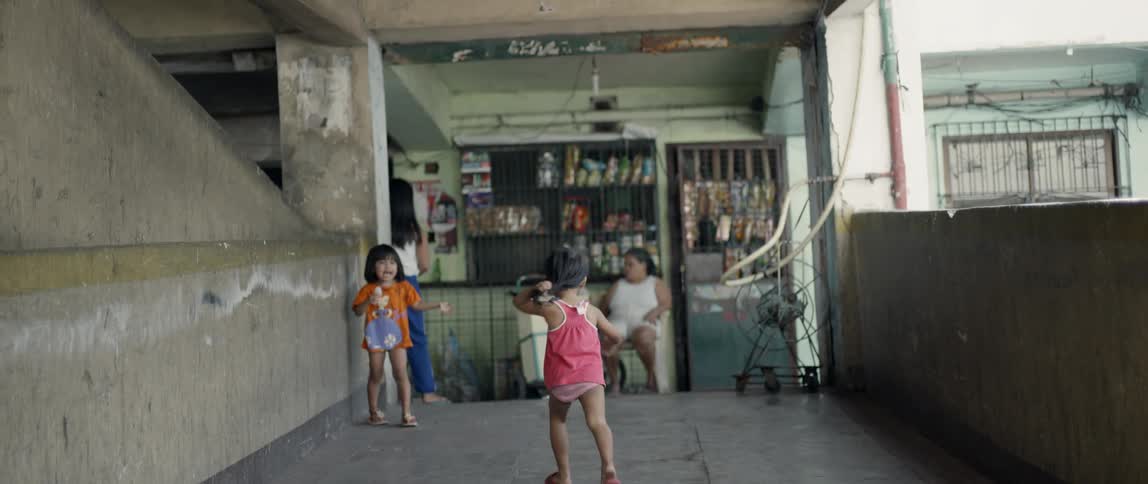 A young girl runs outside on the sidewalk