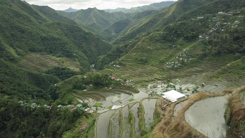 Buildings sit surrounded by tree covered hills
