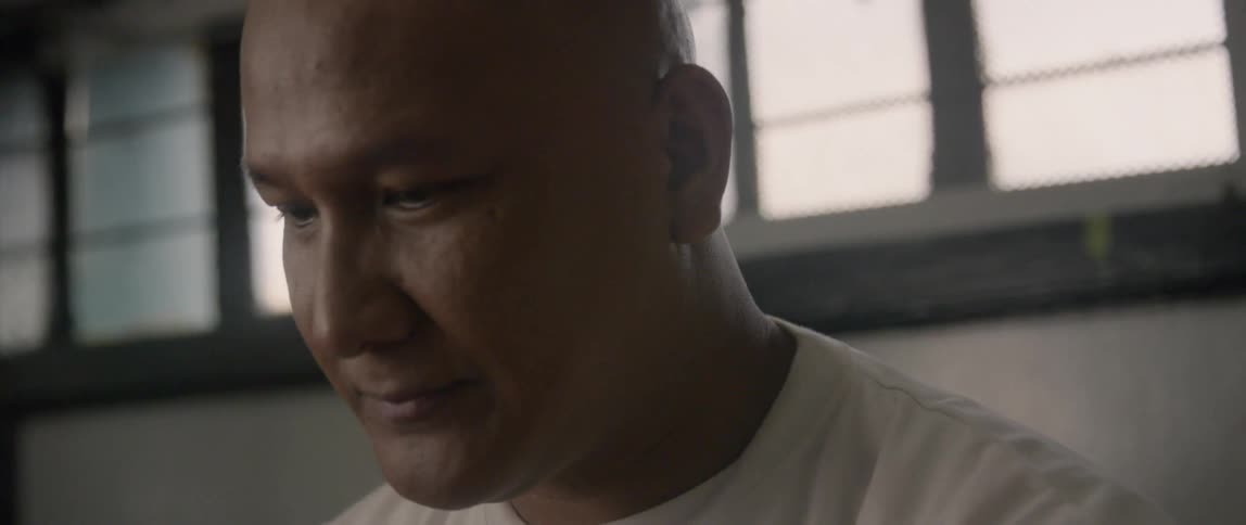 A man looks down smiling
