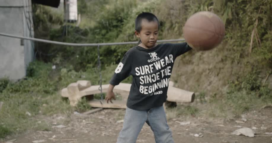 A young boy plays with a basketball