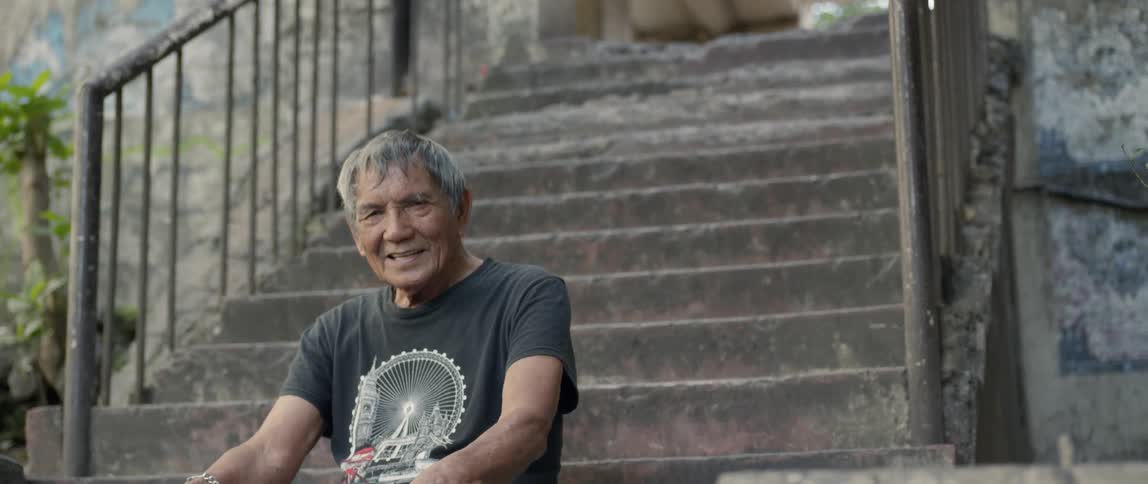 A man sits on the stone steps smiling