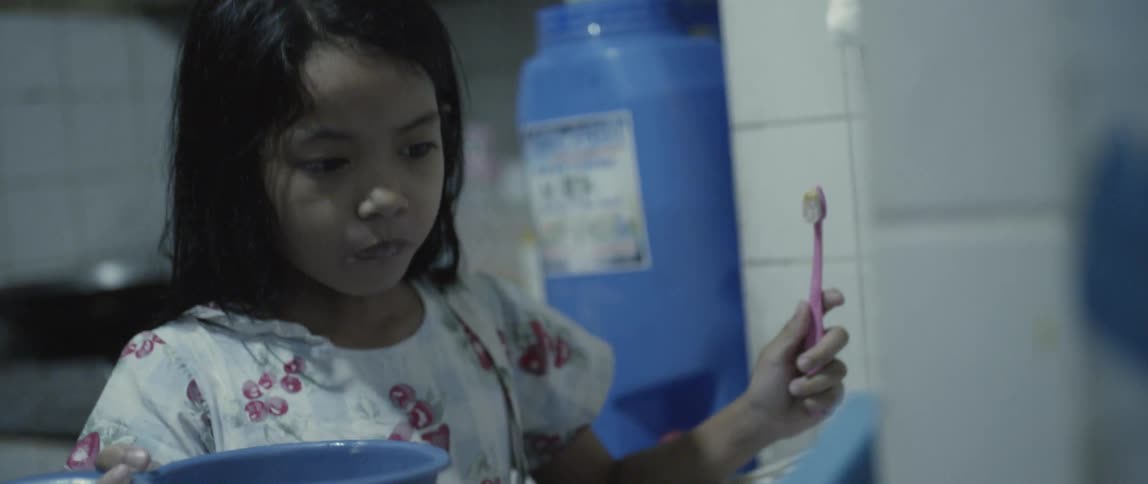 A child brushes their teeth and rinses