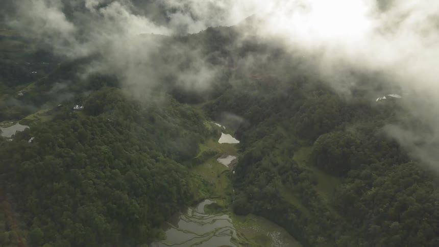 Clouds roll over grassy mountains