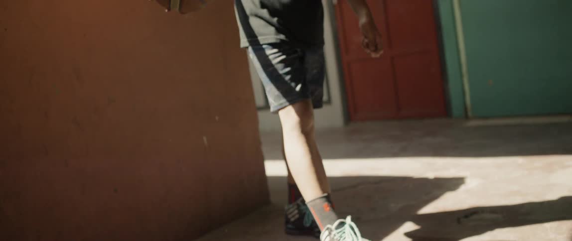 Man wearing shorts bounces a basketball on the floor