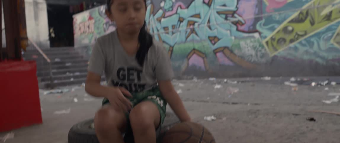Young girl plays with a basketball