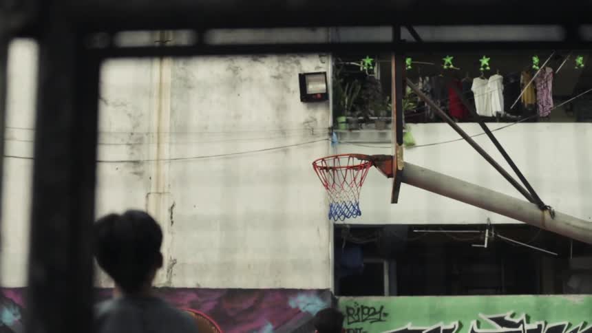 Man throws a basketball into a basketball net