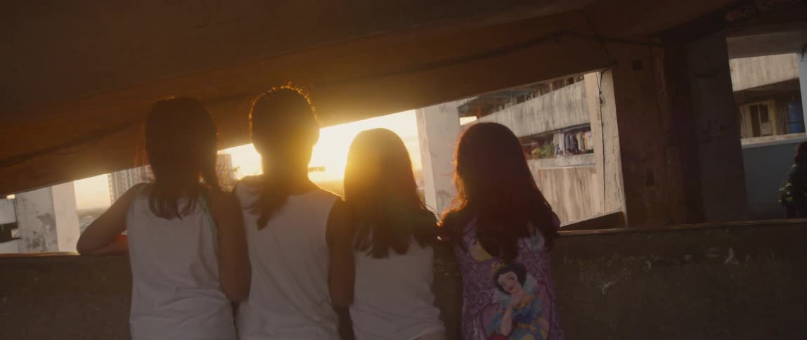 A row of children watch from the balcony