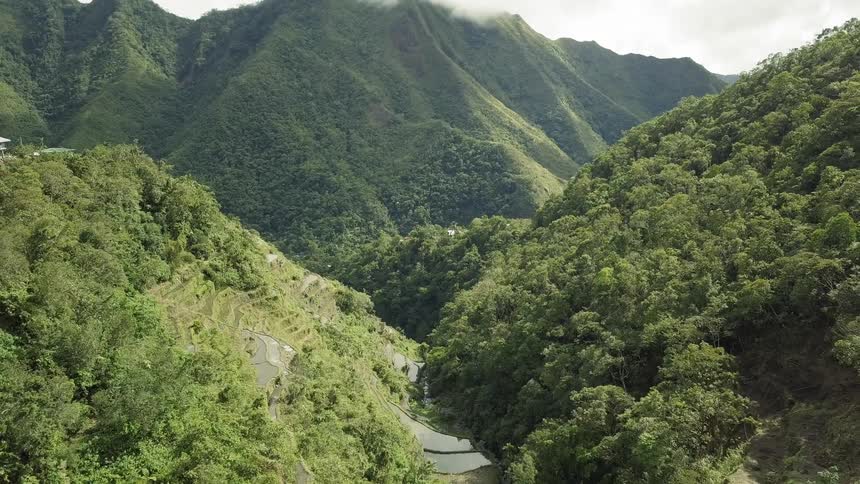 Mountains covered in vegetation and clouds overhead