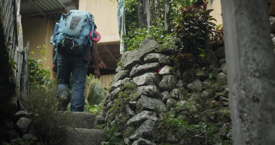 A person with a backpack climbs up the steps