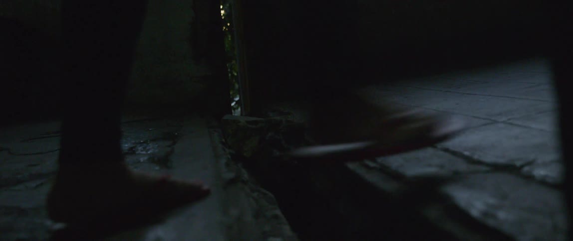 People walk over the wooden floor in the dark