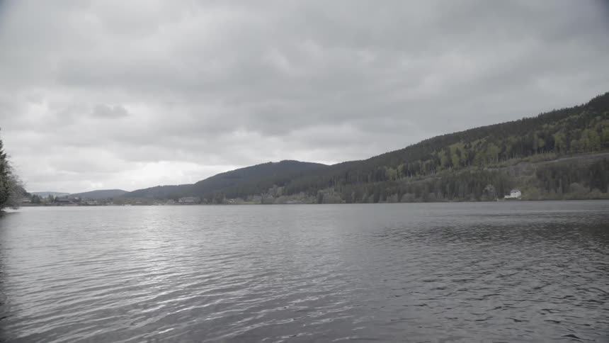 Grey clouds hang above the flowing lake