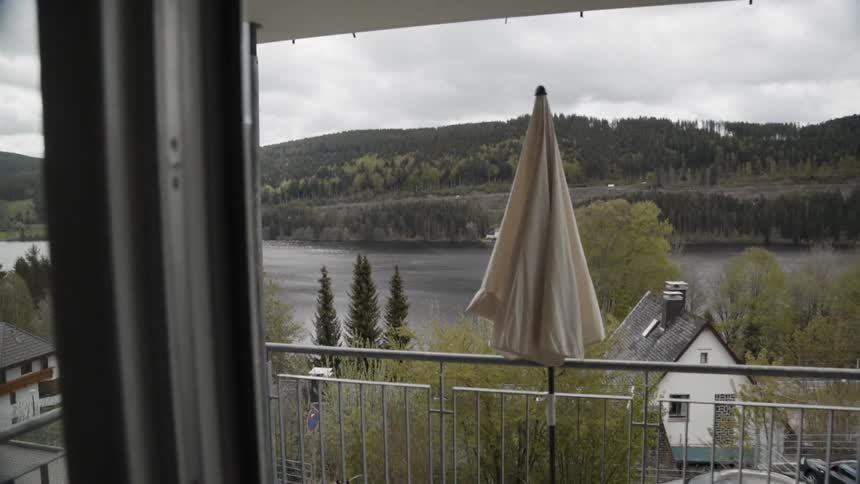 A patio overlooks a mountain lake