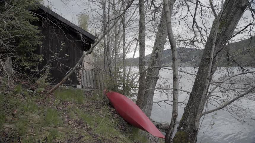 A canoe sits next to a mountain lake