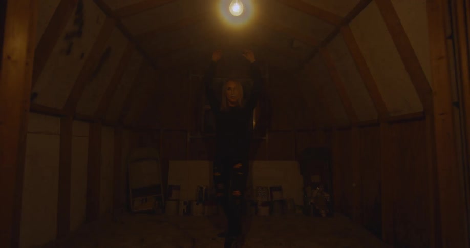 The woman is dancing in the room with flickering light