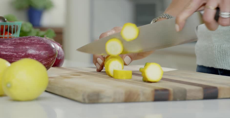 A woman slices squash with a knife