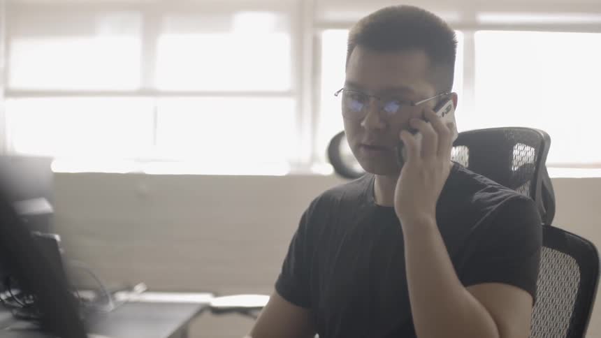 A man uses his phone inside an office