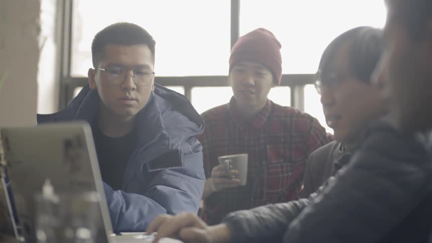 People are gathered around a laptop