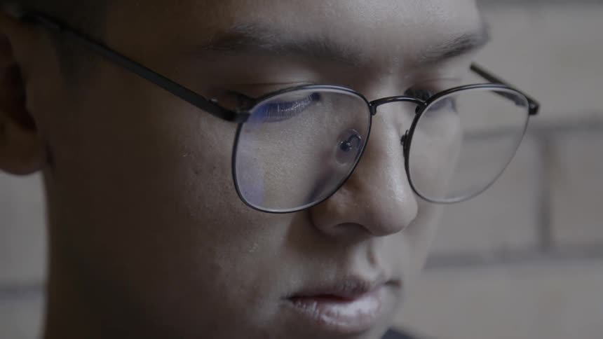 A man is looking down wearing glasses