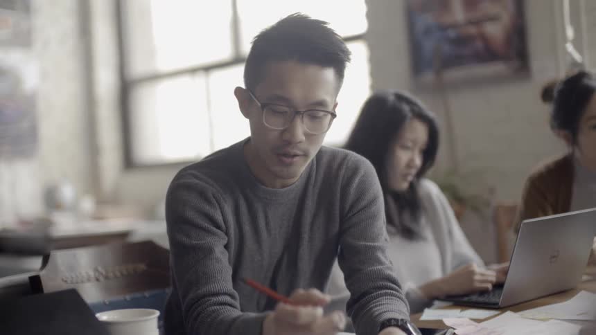 Employees work at a conference table