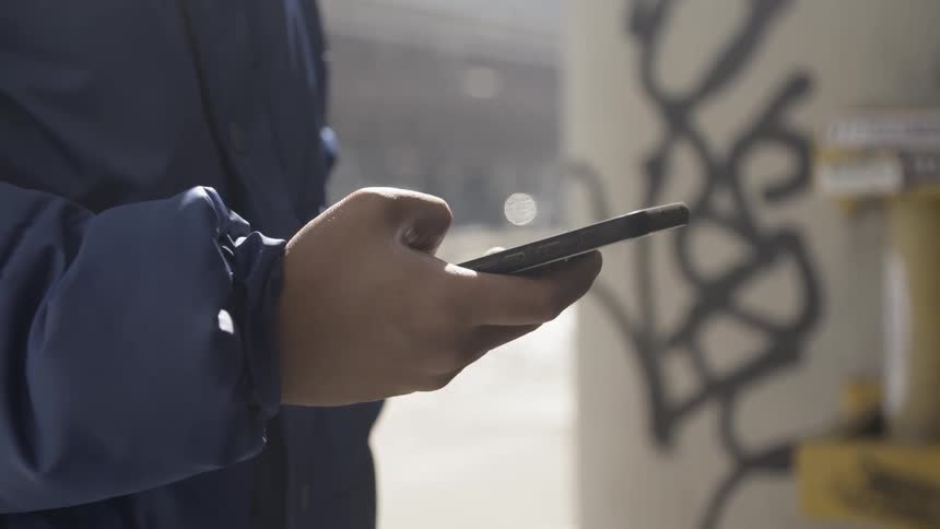 A person uses their cell phone outside
