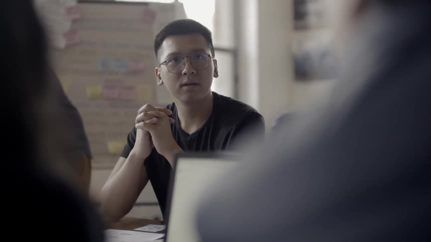 Coworkers talk at a conference table