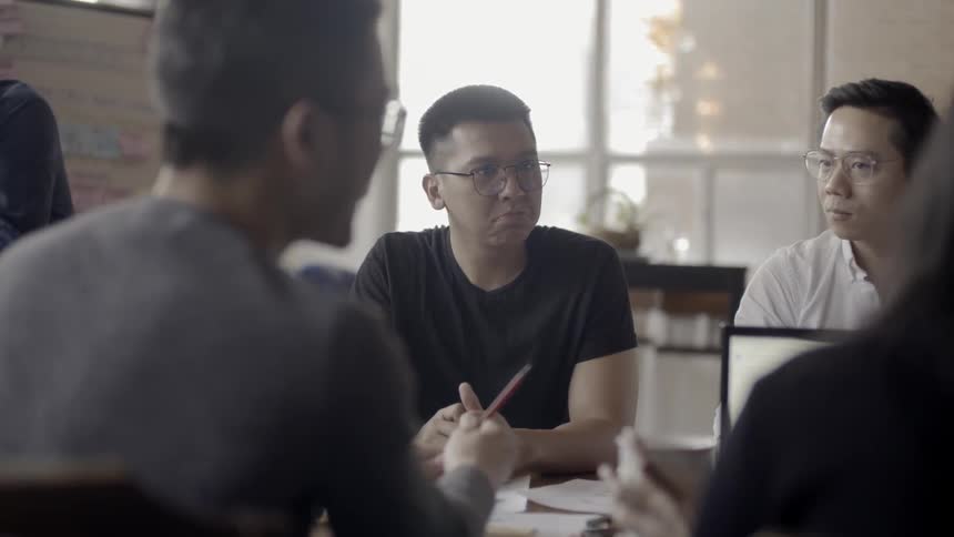 Employees work at a conference table