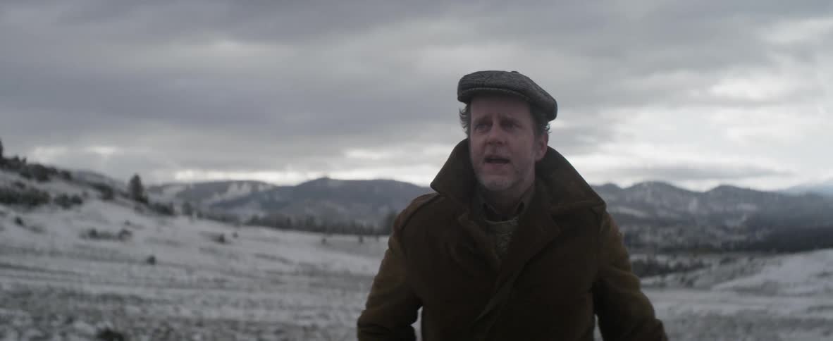 Man walking on a snowy field on a cloudy day