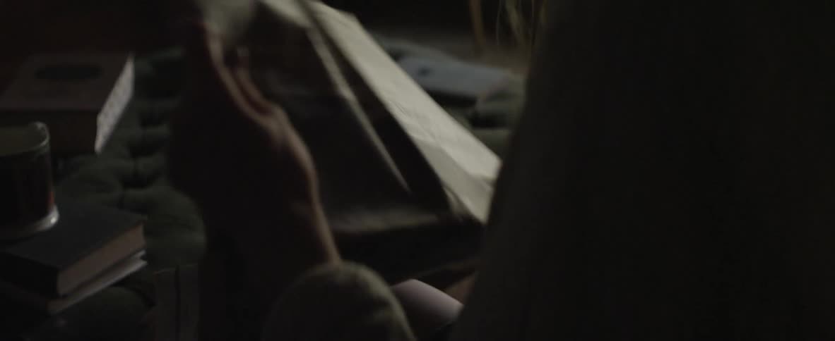 A woman unfolds and reads a newspaper