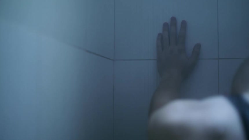 Man leans against the wall while showering