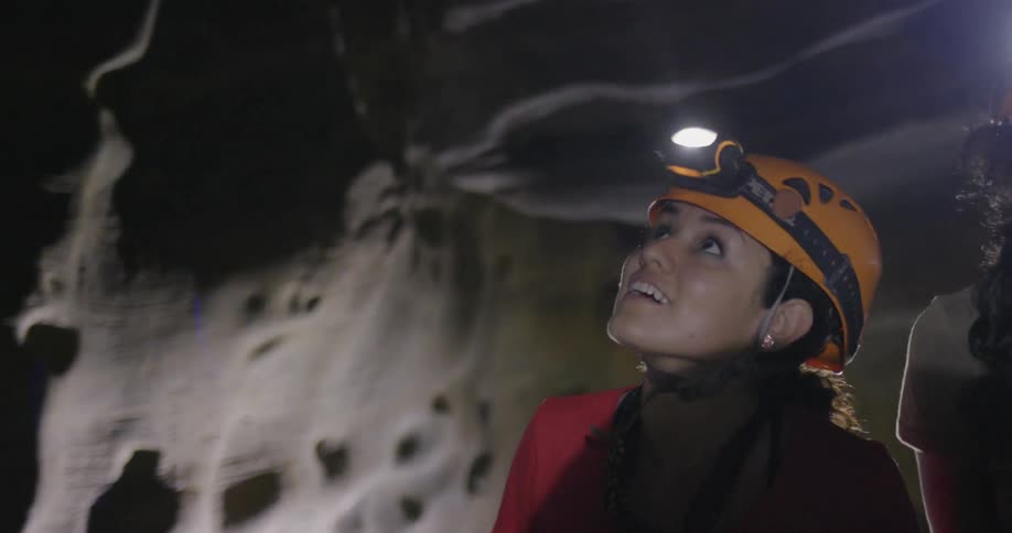 Two women explore a dark cave
