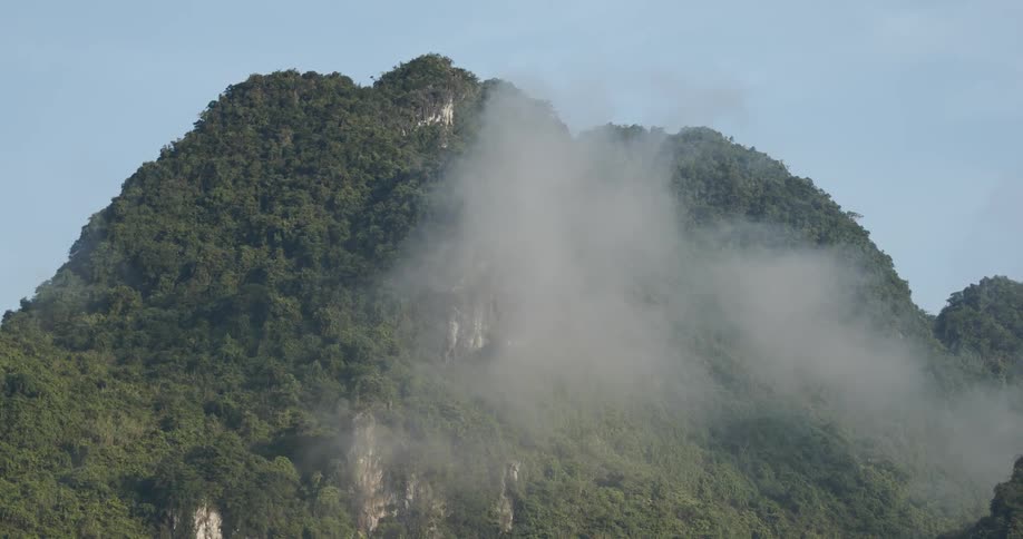Fog rolls over grassy mountains