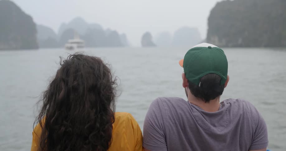 A man and woman ride on a boat together