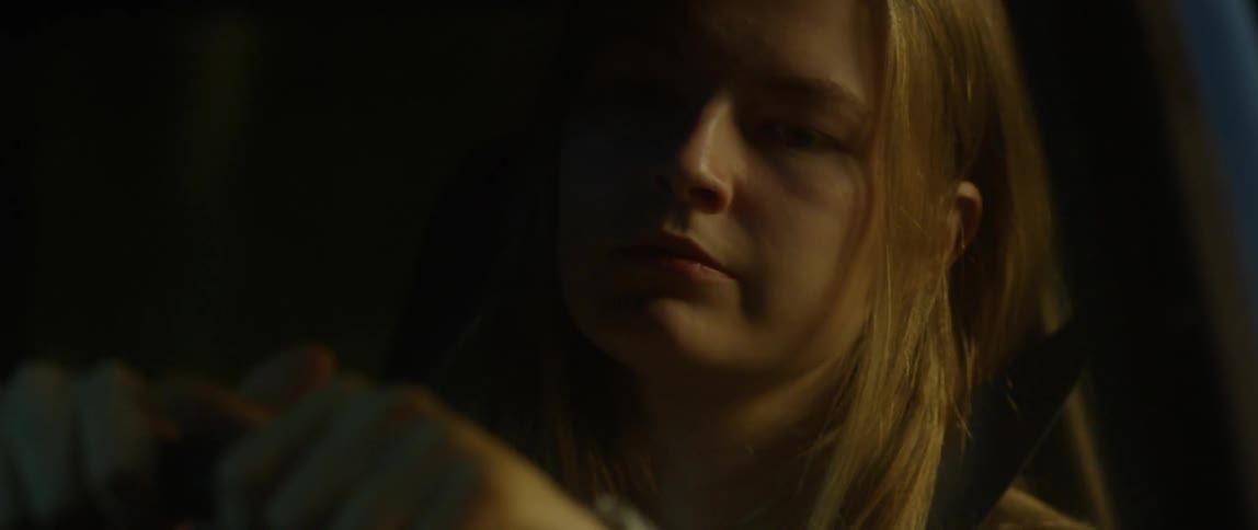 A woman looks to her side out of the vehicle